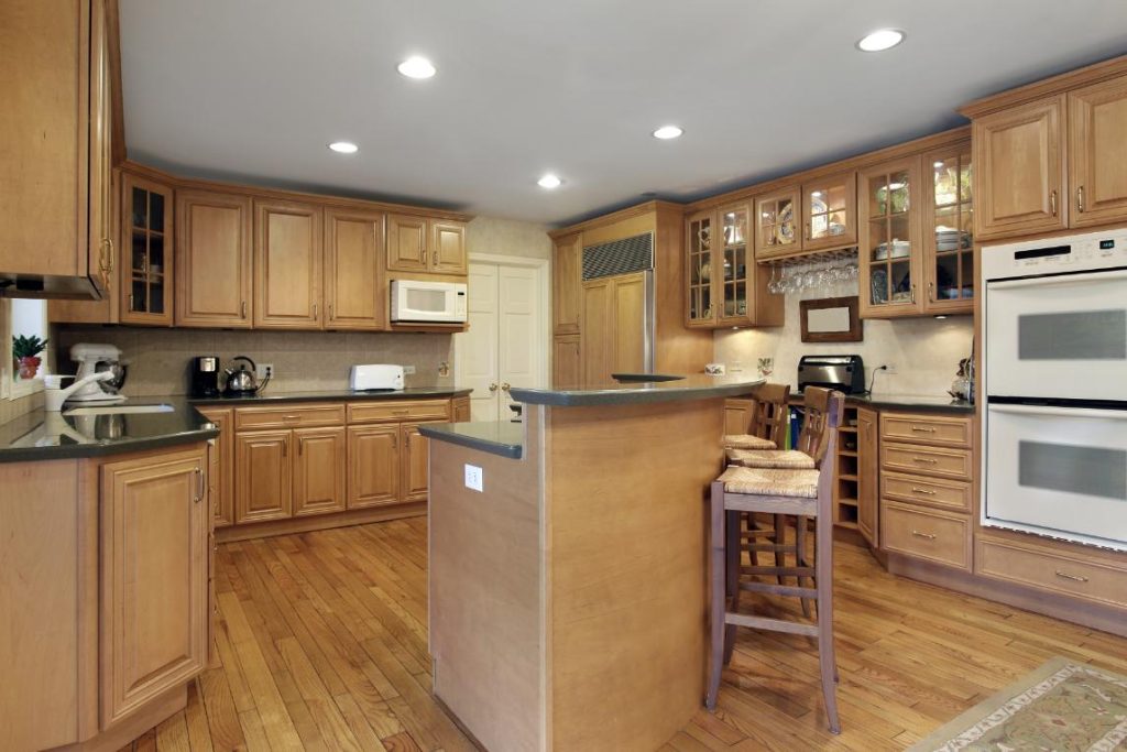 Kitchen with oak cabinetry and double decker island.